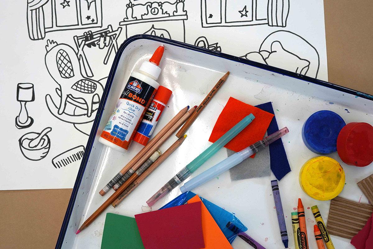Arts and craft materials on a tray over a printed Goodnight Moon inspired coloring page